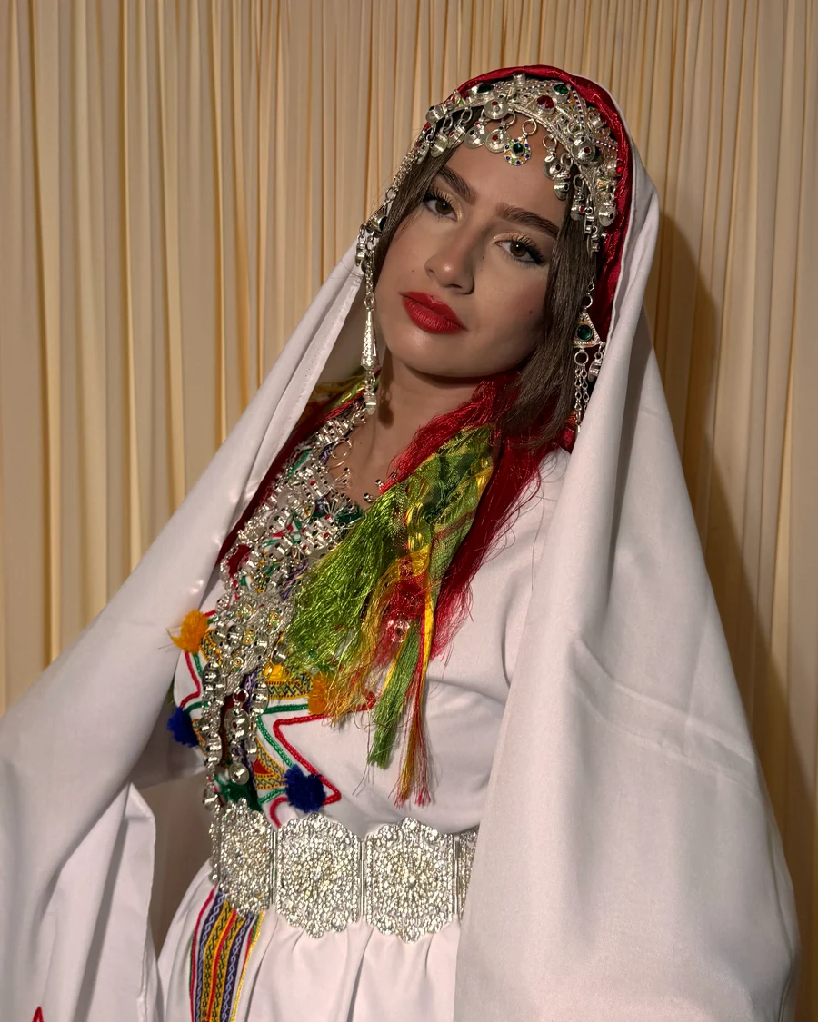 Mariée en tenue chelha du Souss, robe blanche brodée, voile drapé et parure de bijoux en argent