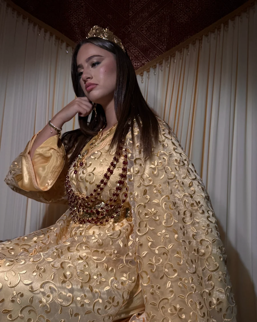 Mansouria dorée brodée, portée avec couronne et colliers de perles rouges